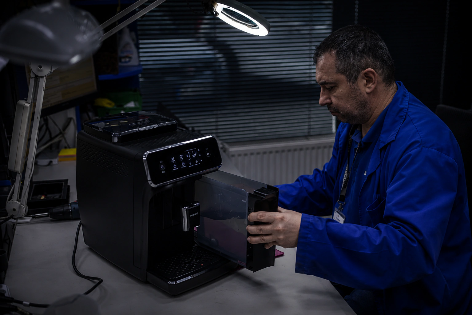 Tehnician Adial reparând un aparat electrocasnic în atelier